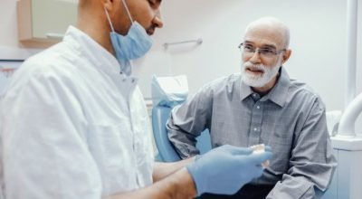 1_dentista_explica_sobre_implante_a_paciente_magnifc-597500.jpeg